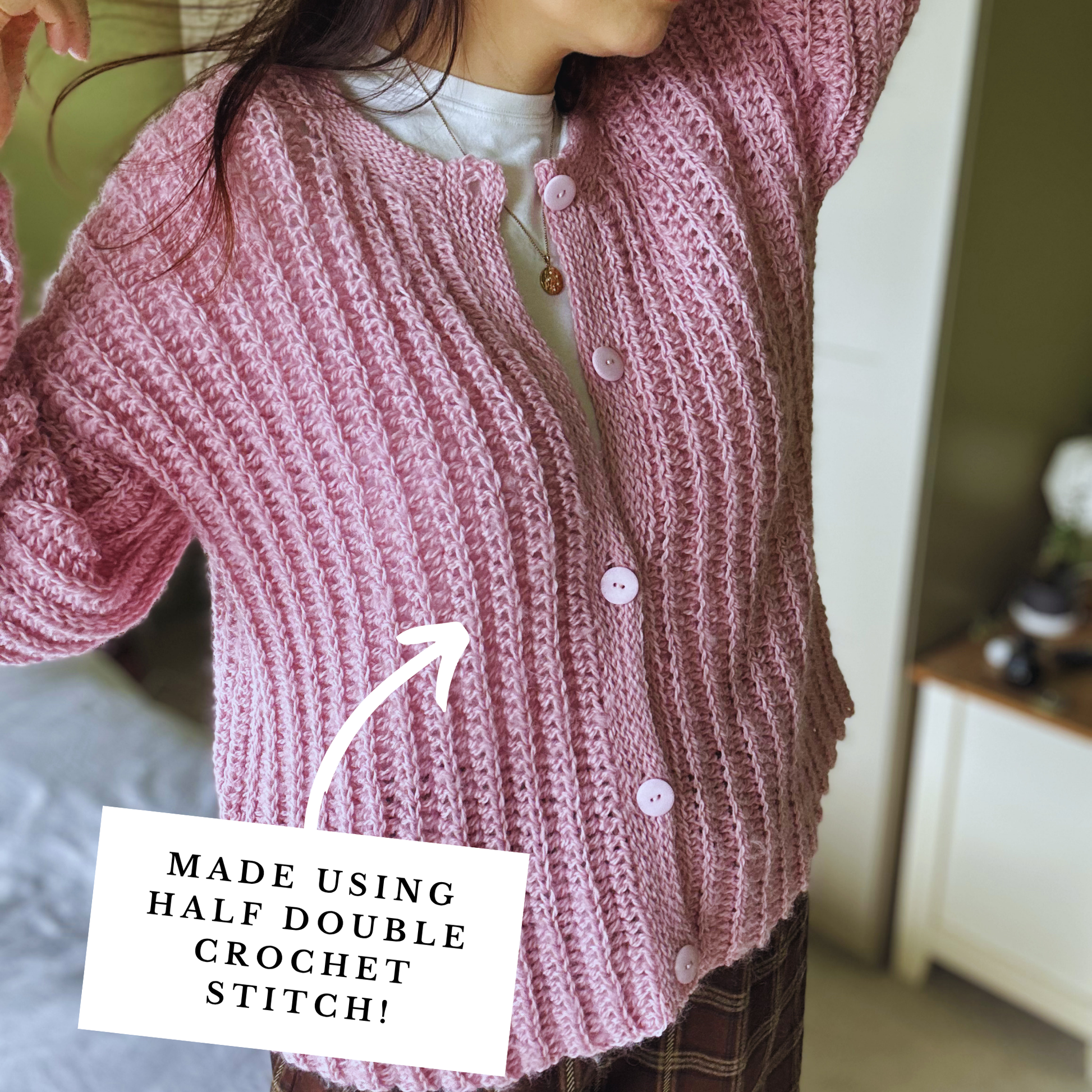 Person wearing a pink knitted cardigan with text indicating the stitch used.