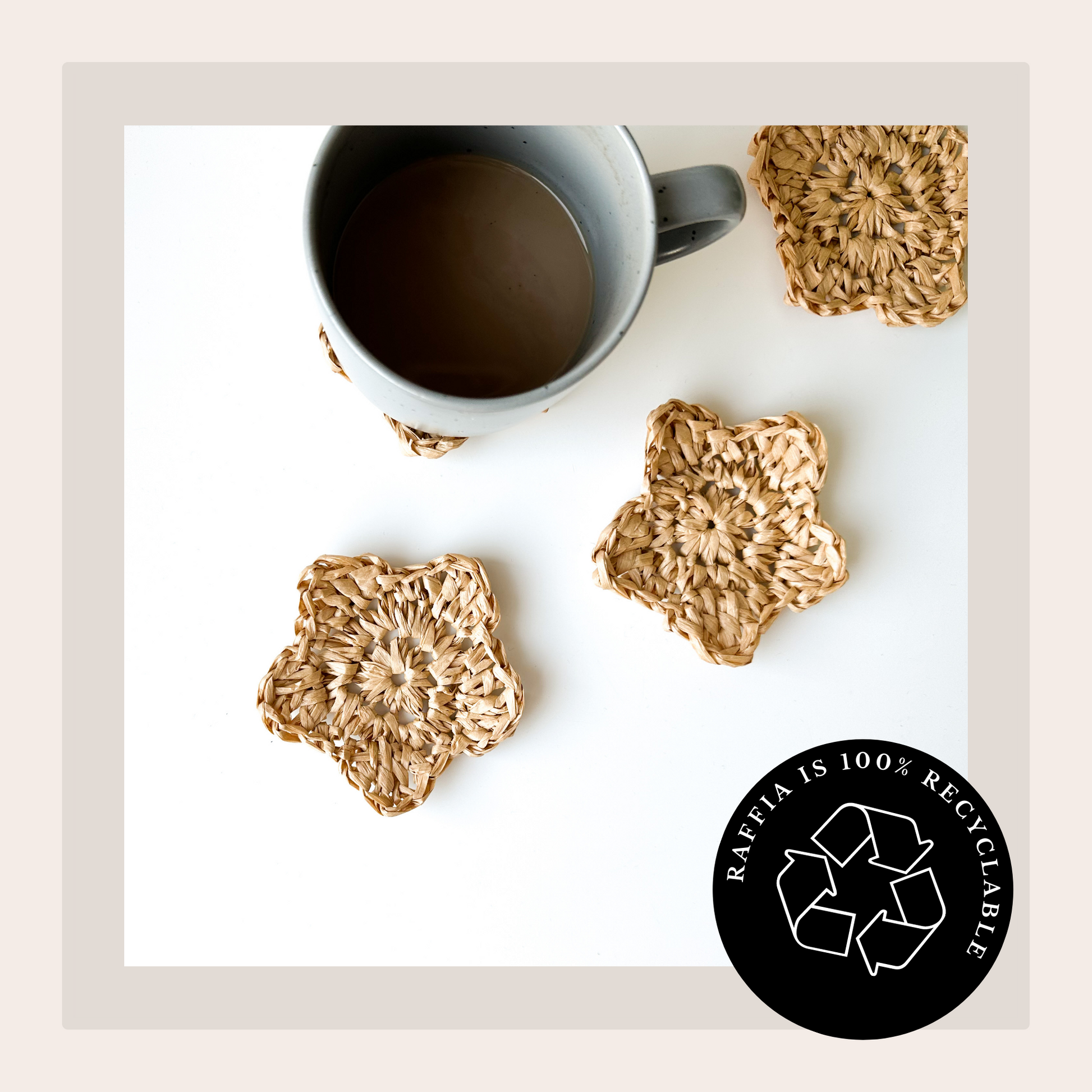 Cat Kemble crochet pattern cover image showing natural raffia yarn flower coasters. Top down shot with a coffee cup resting on one of the three coasters in view on a white coffee table top. Raffia is 100% recyclable black circular graphic white text